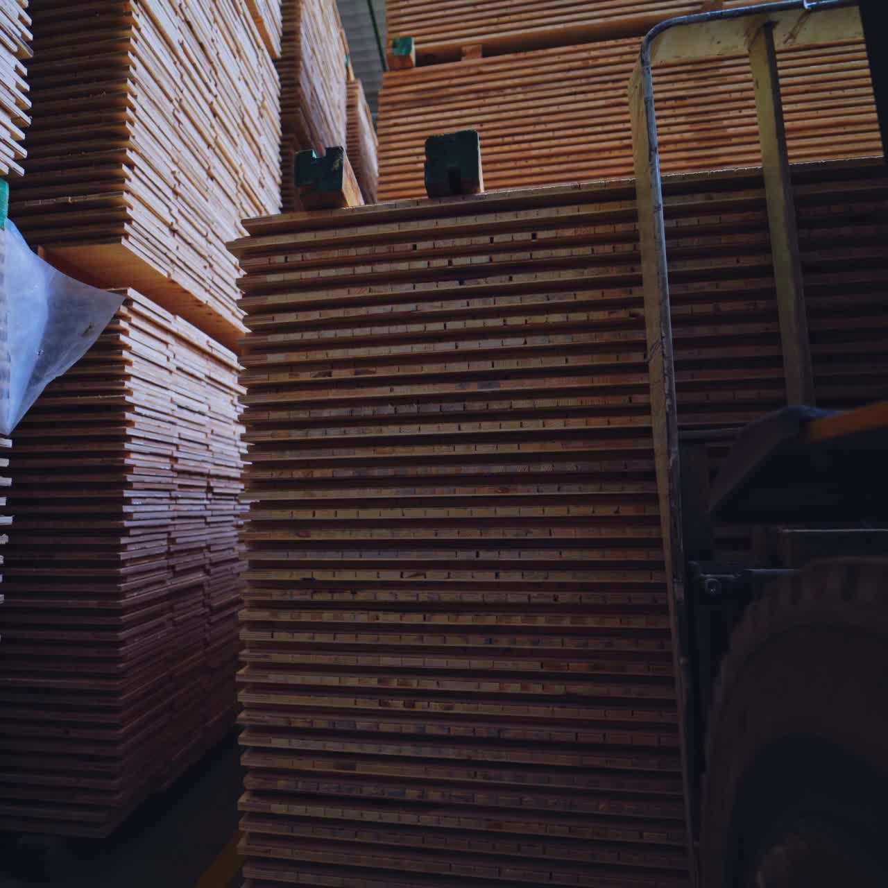 Forklift Moving and Storing Stacks of Lumber in a Warehouse