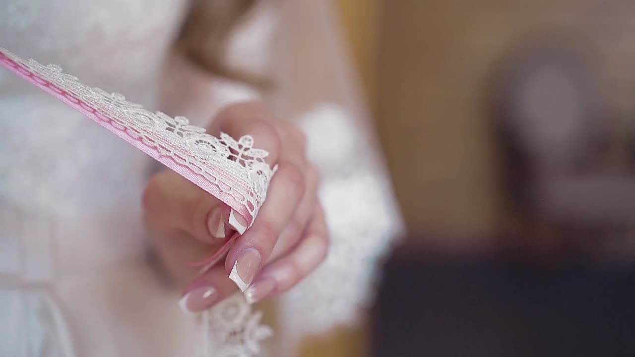 Young girl is playing with ribbons woven into a bouquet of flowers