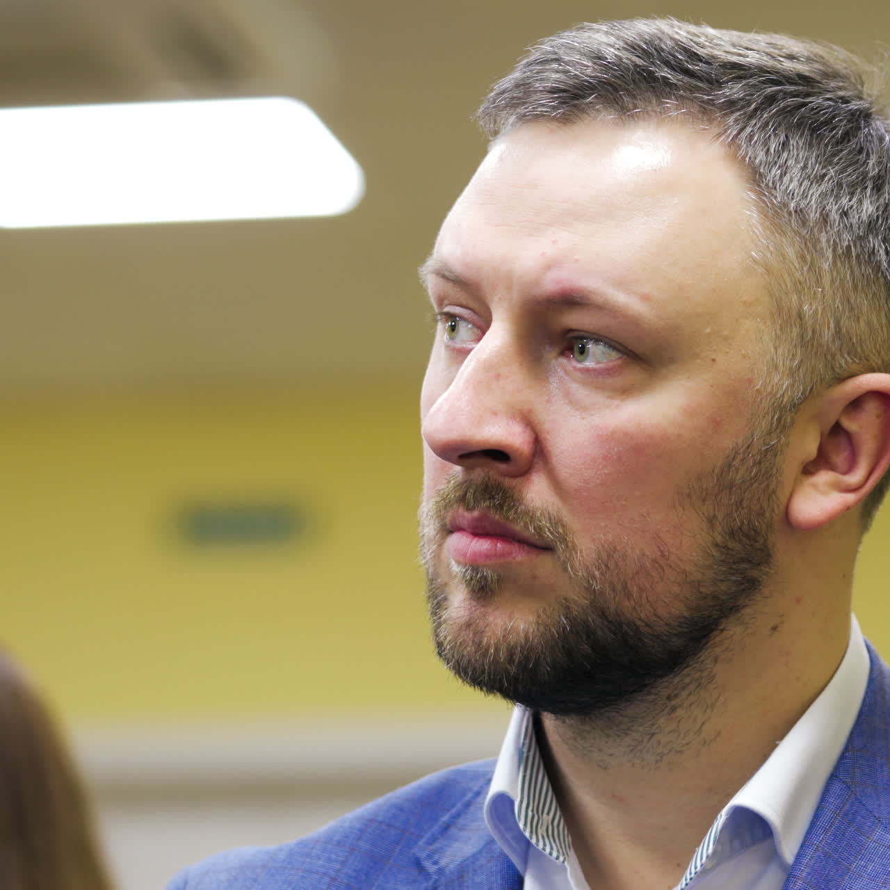 Serious man in suit listens the lecture in the business forum. Portrait of a businessman listening the seminar in the conference hall. Close-up.