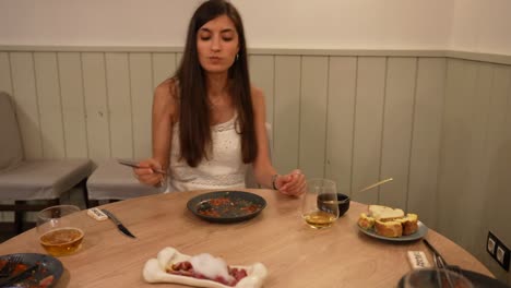 slow motion shot of beautiful girl using a fork to try a gourmet dish