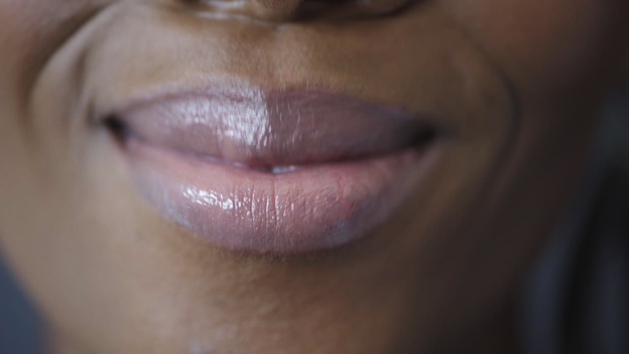 primer plano de una mujer afroamericana con labios brillantes sonriendo feliz mostrando dientes blancos saludables concepto de salud dental