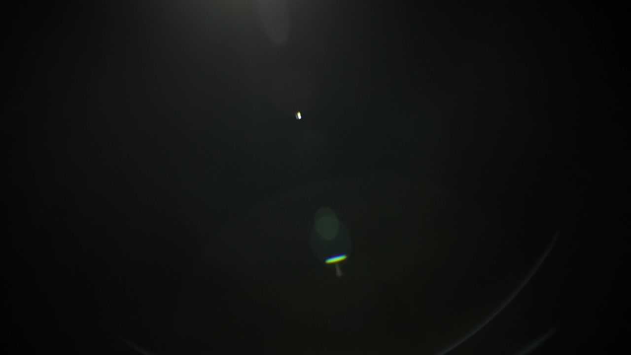 Lens flare fading out to black background. Slow motion