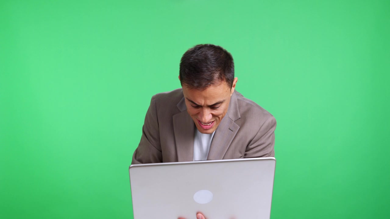 Stressed businessman working on laptop gets angry