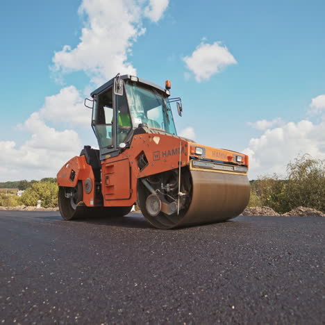 laying a new asphalt on the road. road repair machine with heavy vibration roller compactor