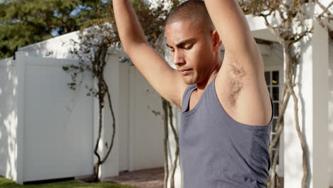 focused biracial man practicing yoga in sunny garden, slow motion