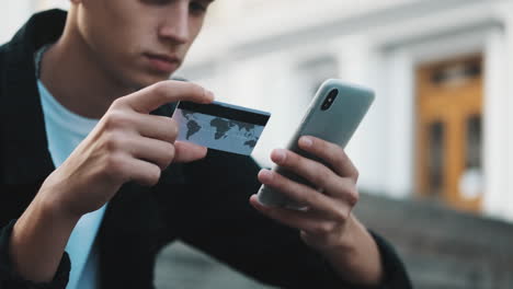 young student guy paying online with credit card.