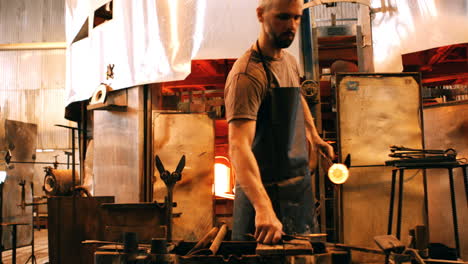 glassblower shaping a molten glass