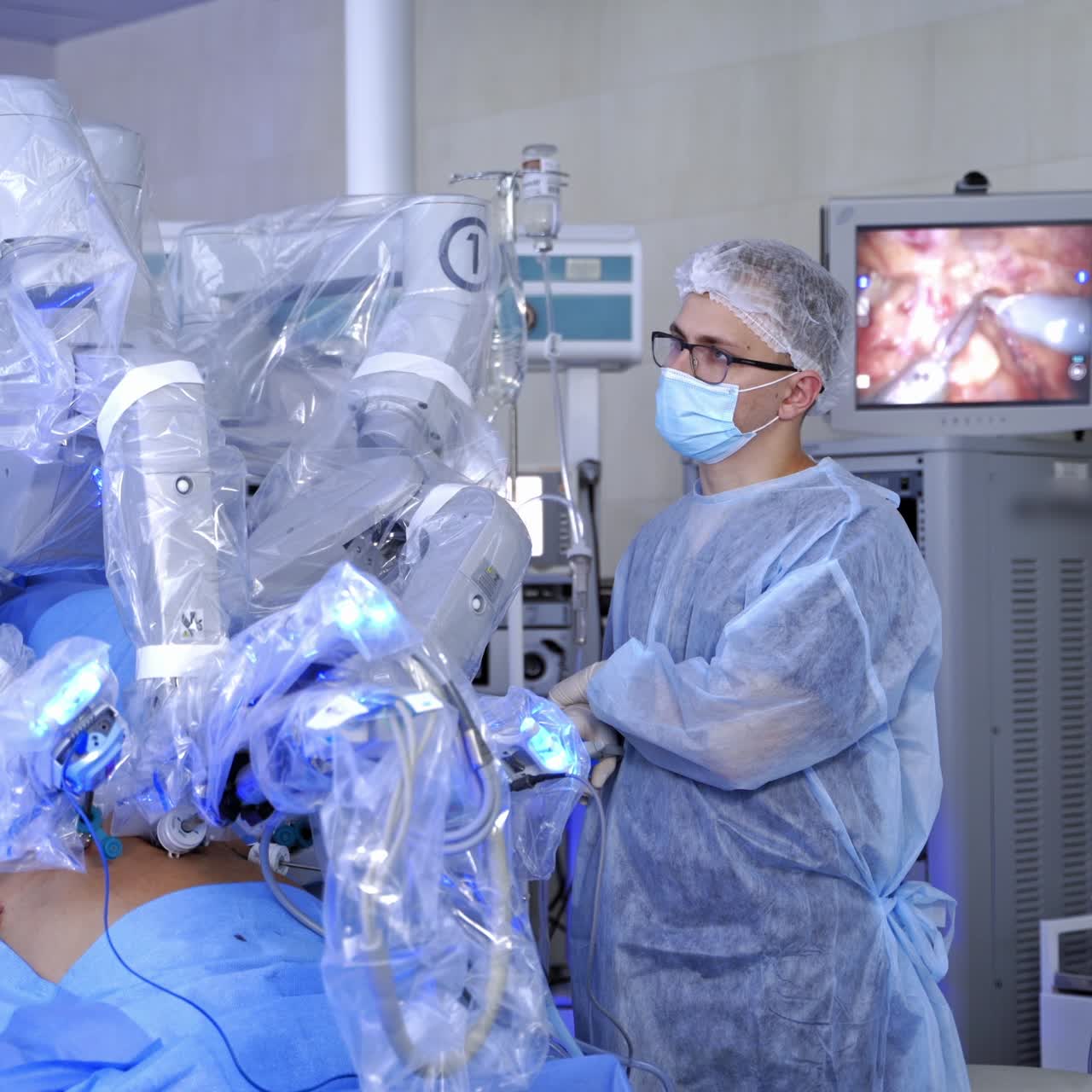 Doctor near robotic equipment in surgical room. Minimally invasive surgical innovation. Detailed process of futuristic operation on the screen of monitor.