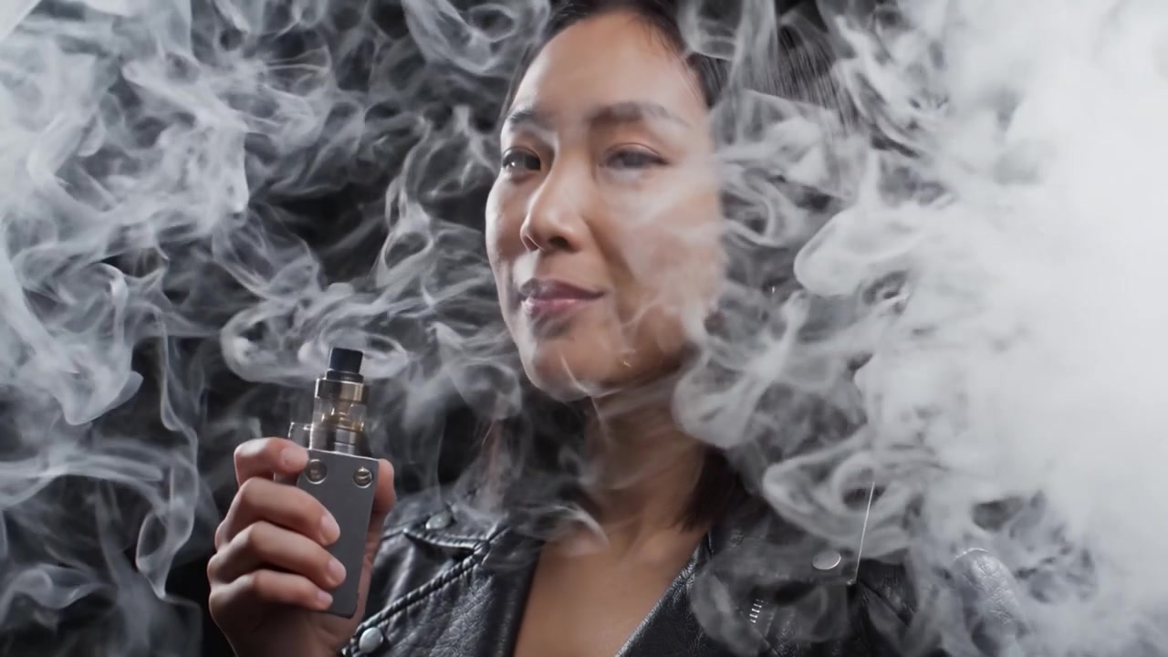 A Stylish Individual Enjoying Vaping: Captured Moments from the First and Last Frames of a Captivating Video Featuring Smoke and Elegance
