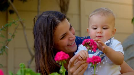 Mutter-Und-Kleiner-Junge-Halten-Blumen-Im-Garten-4k