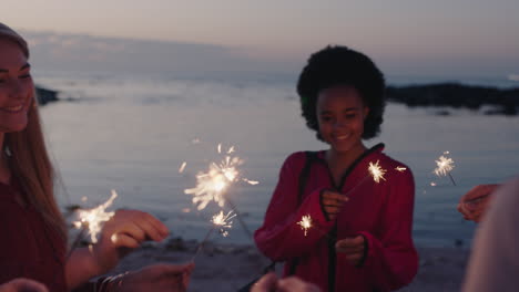 Eine-Gruppe-Von-Freunden-Feiert-Mit-Wunderkerzen-Am-Strand-Und-Genießt-Die-Silvester-Strandparty-Bei-Sonnenuntergang