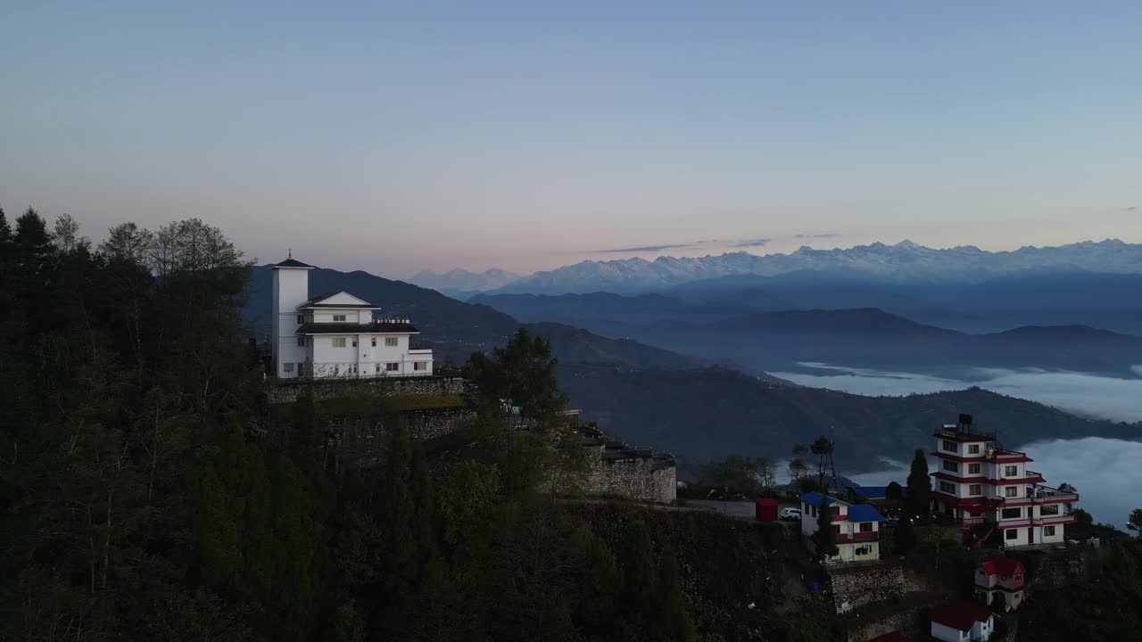 Luxury mystic white hotel on ridge at sunrise, low clouds in valleys, aerial parallax