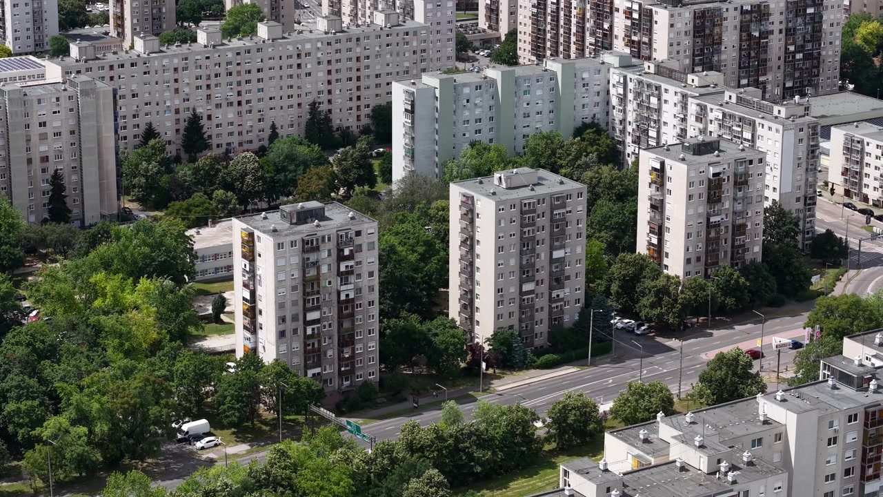 Esta vista de ángulo alto captura edificios de apartamentos prefabricados de la era socialista rodeados de exuberantes árboles verdes en un distrito residencial de Hungría