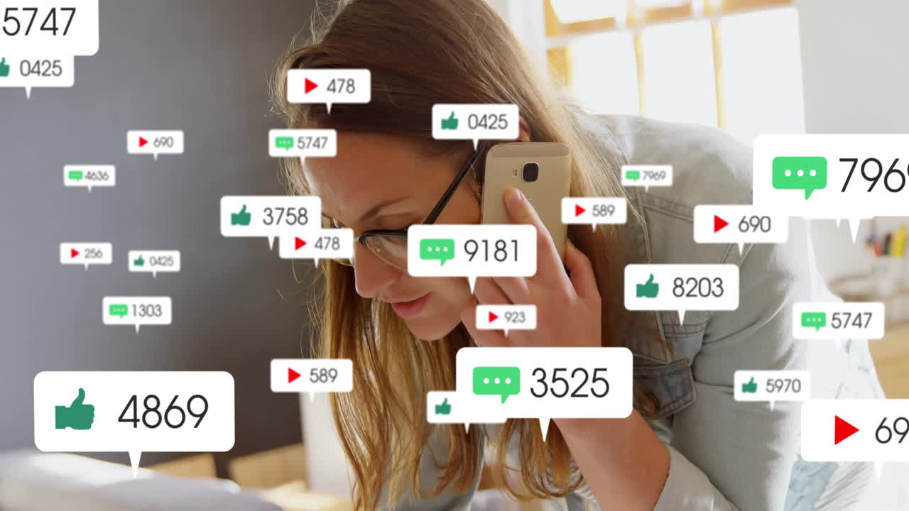 woman leaning over desk holding smartphone, reviewing social media metrics with floating icons