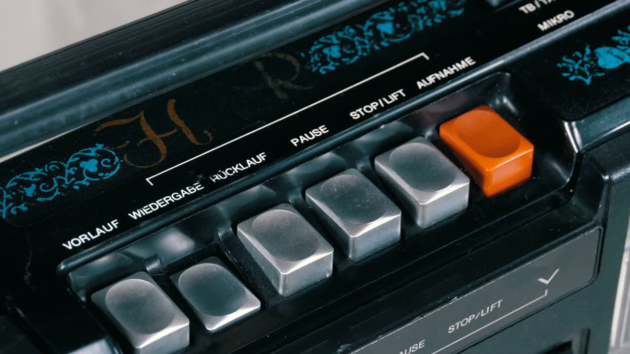 presionando el botón de un grabador de cinta, jugar, detener, grabar, ff, rew