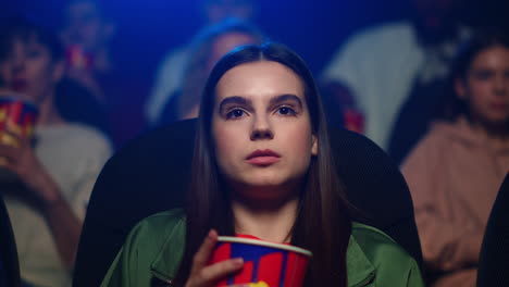 una chica asustada viendo una película de terror.