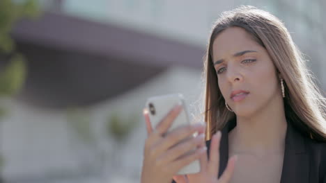 chica conmocionada leyendo un mensaje a través de un teléfono inteligente