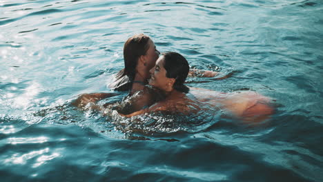 two women swimming and playing in a lake