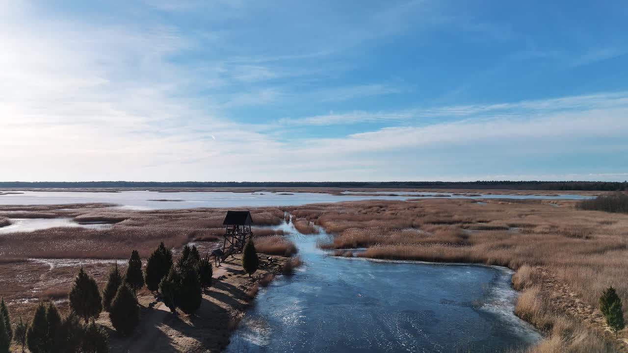 torre de observación de aves de riekstusala en el lago kaniera lapmezciems, letonia sendero de caña en el parque nacional de kemeri fondo con pantanos y muchos lagos pequeños