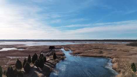 Torre-De-Observación-De-Aves-De-Riekstusala-En-El-Lago-Kaniera-Lapmezciems,-Sendero-De-Caña-De-Letonia-En-El-Fondo-Del-Parque-Nacional-De-Kemeri-Con-Pantanos-Y-Muchos-Lagos-Pequeños