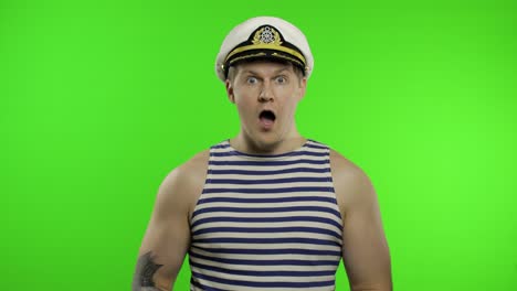 young sailor man expresses shock, looks surprised. seaman guy in sailor's vest