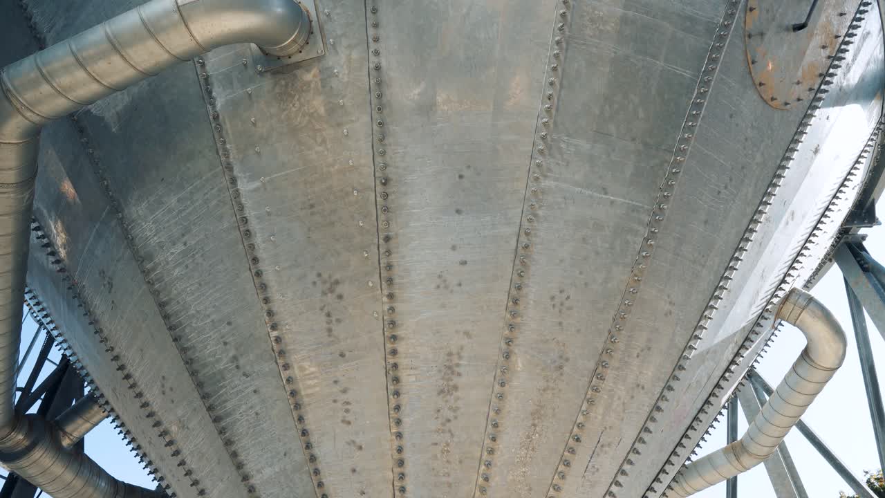 A metal tower with a grain cone. Elevator and granary. Pipes and bolts on the structure