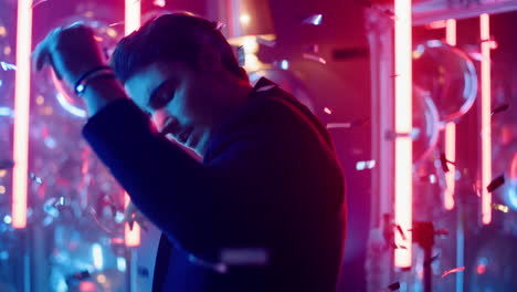 sexy guy making body movements on neon background. man dancing in nightclub