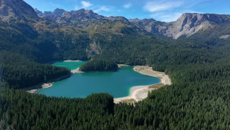 aerial view of a picturesque mountain lake surrounded by forest and mountains