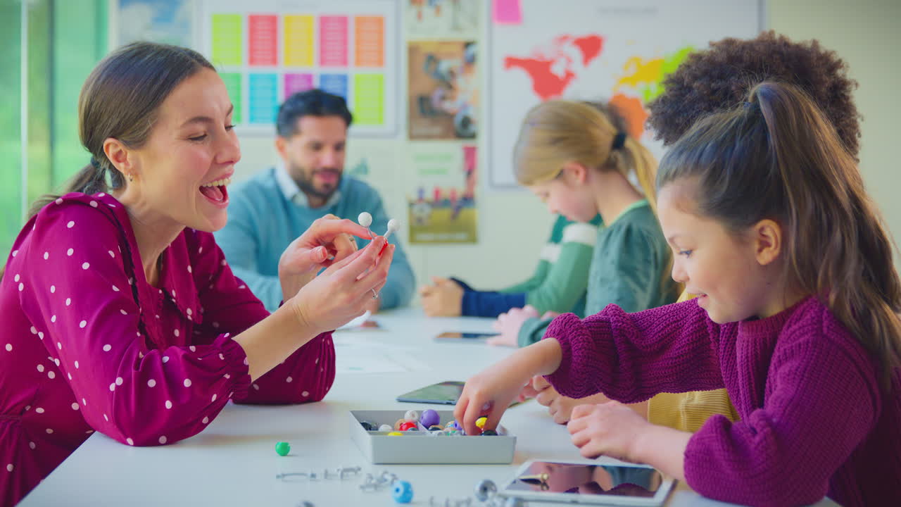 estudiantes multiculturales con profesores en el aula estudiando el modelo molecular en la clase de ciencias