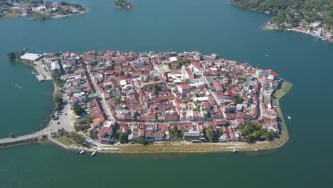 drone aerial shot of island in the middle of a lake in peten flores, guatemala