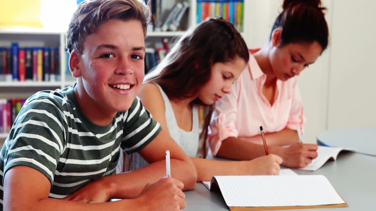 niños de la escuela haciendo la tarea en la biblioteca