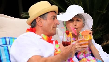 mature couple with garlands enjoying cocktails