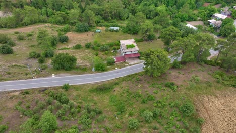 vista aérea de una carretera rural y una casa en el campo