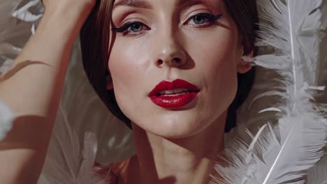 elegant woman with red lips and white feathers