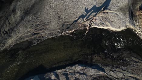 top shot badly eroded river with a fallen tree