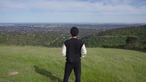 indian sikh man standing on the meadow, staring at beautiful view - push in