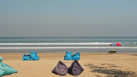 Waves-rolling-in-at-sunrise-with-golden-sand-beach-in-foreground