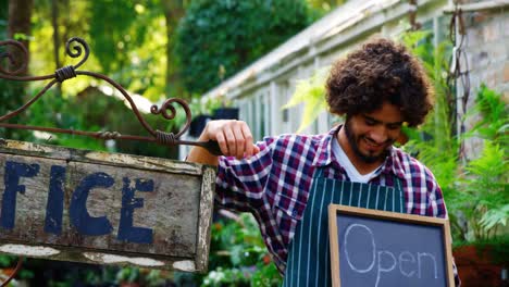 jardinero con un letrero abierto