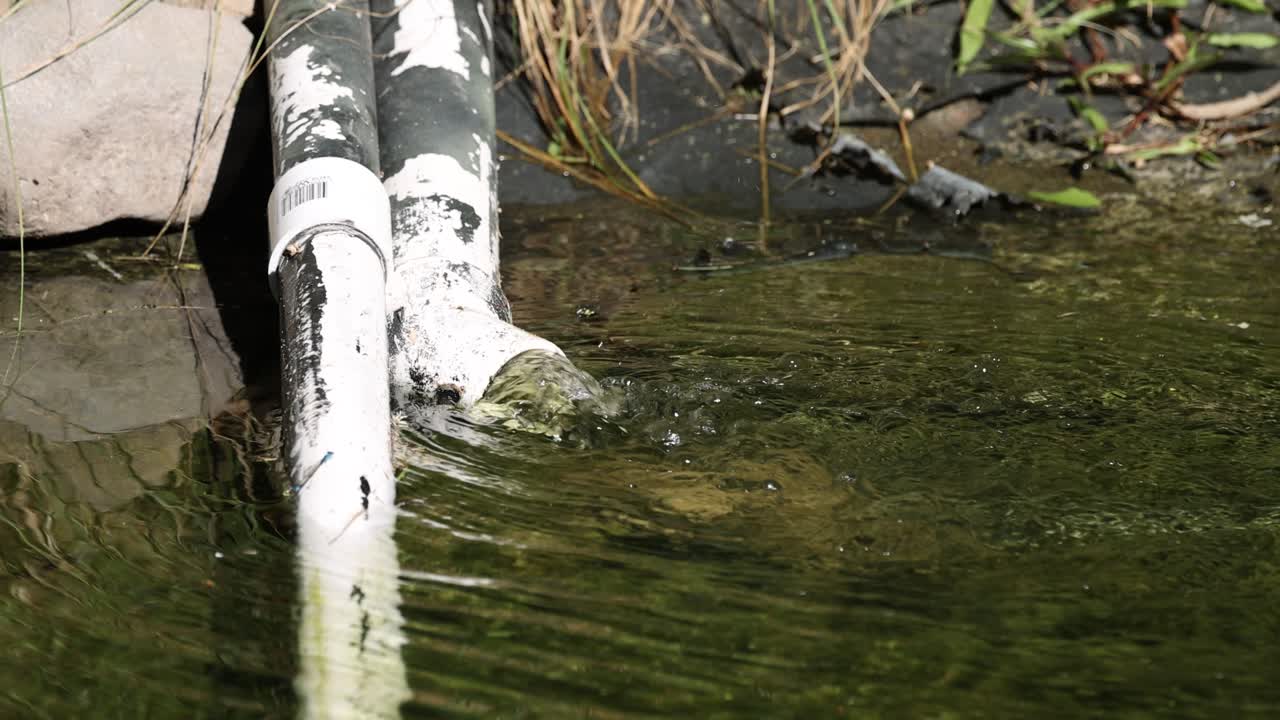 Water flowing from a pipe into a pond