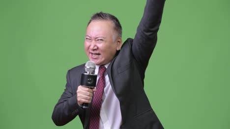 마이크를 사용하는 성숙한 일본 사업가