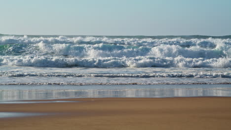 Stormy-waves-crashing-beach-on-sunny-day.-Dangerous-ocean-water-rolling-to-sandy