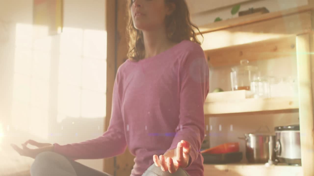 animación de puntos de luz sobre una mujer caucásica practicando yoga y meditando