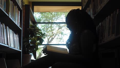 Young-Black-Woman-Reads-in-a-Library---Dolly-Back