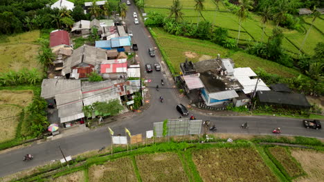 motorcycle and car traffic at t-junction of countryside road in bali