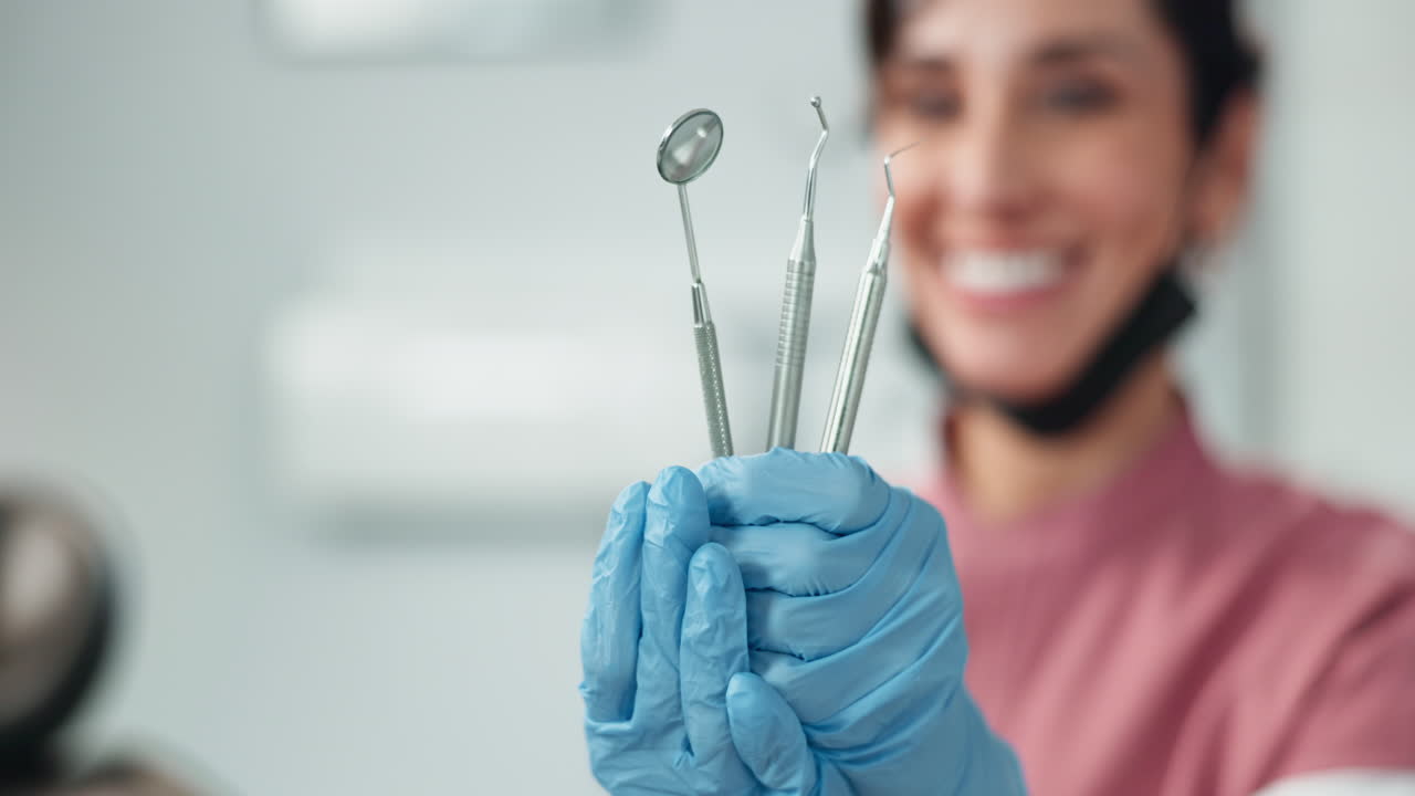 um dentista segura ferramentas dentárias e sorri