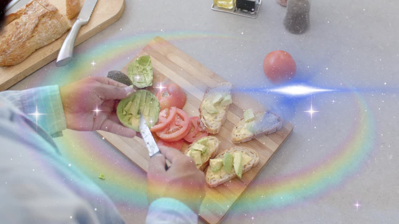 Cook grabbing avocado half, scoring and assembling toasts on board, sparkles sweeping over hands