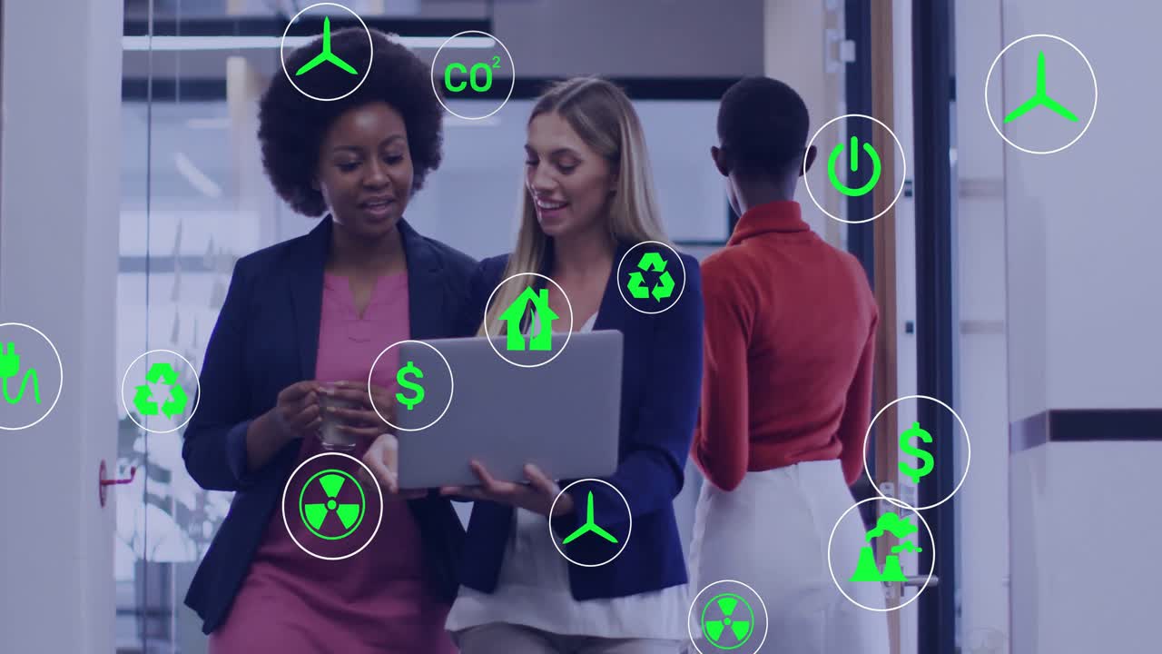 Two businesswomen walking causing floating energy icons to appear while analyzing metrics on laptop