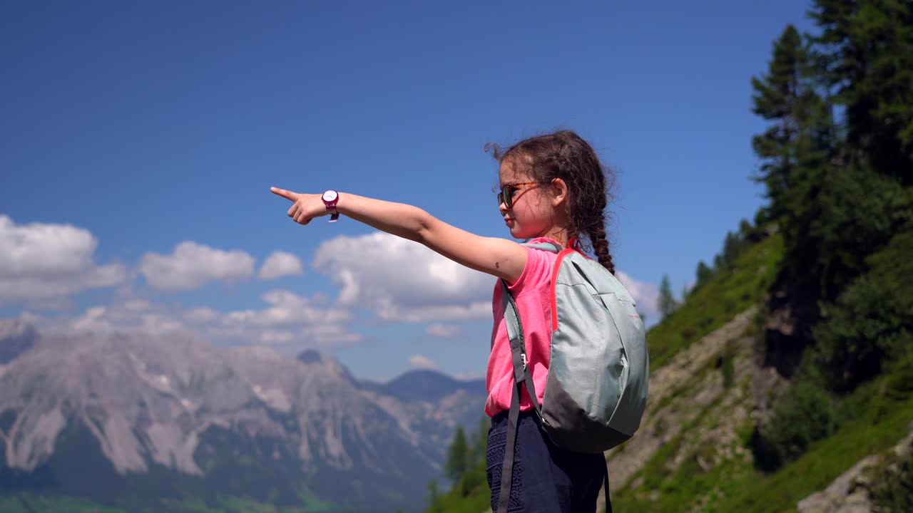 Ragazza che fa un'escursione in una bella giornata estiva nelle montagne delle Alpi Austria, che riposa sulla roccia e ammira una vista incredibile sulle cime delle montagne. Tempo libero attivo per le vacanze in famiglia con i bambini. Divertimento all'aria aperta e attività salutare