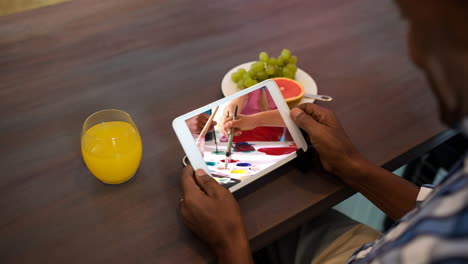 Animation of african american man watching children painting on tablet screen