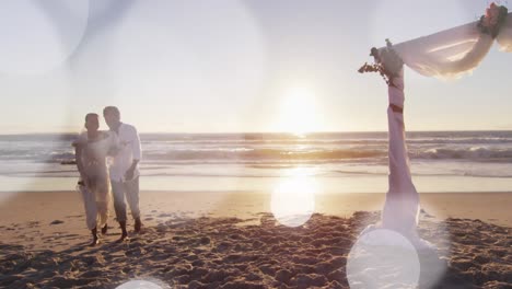 animation of dots over happy african american newly married couple on beach